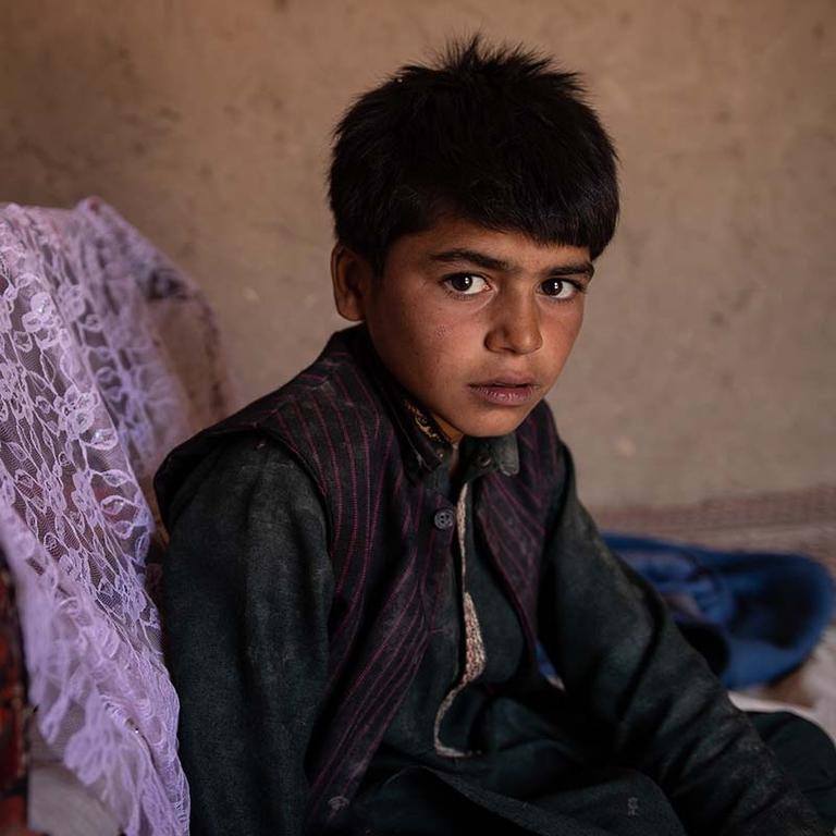 In Afghanistan, a boy sits alone in a room. In Afghanistan, a boy sits alone in a room.