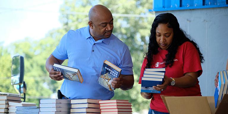 TN, Save the Children staff and volunteers organize books at a book distribution event. TN, Save the Children staff and volunteers organize books at a book distribution event.